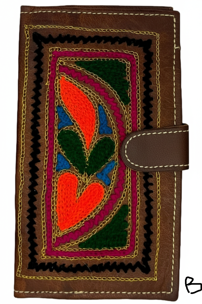Three natural leather wallets with embroidered floral and geometric patterns in colors brown, green, red, and purple, featuring a zipper and a button closure.